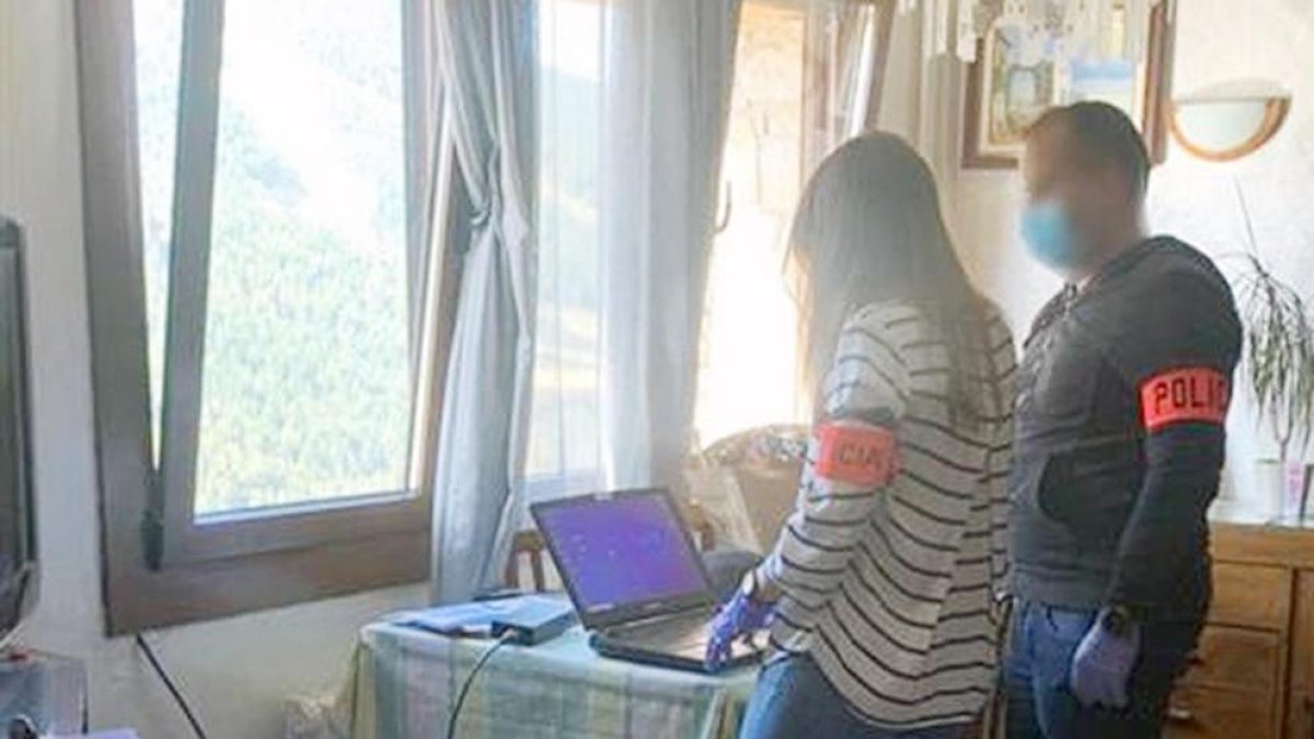 Agents de la policia al domicili del detingut amb el seu ordinador.