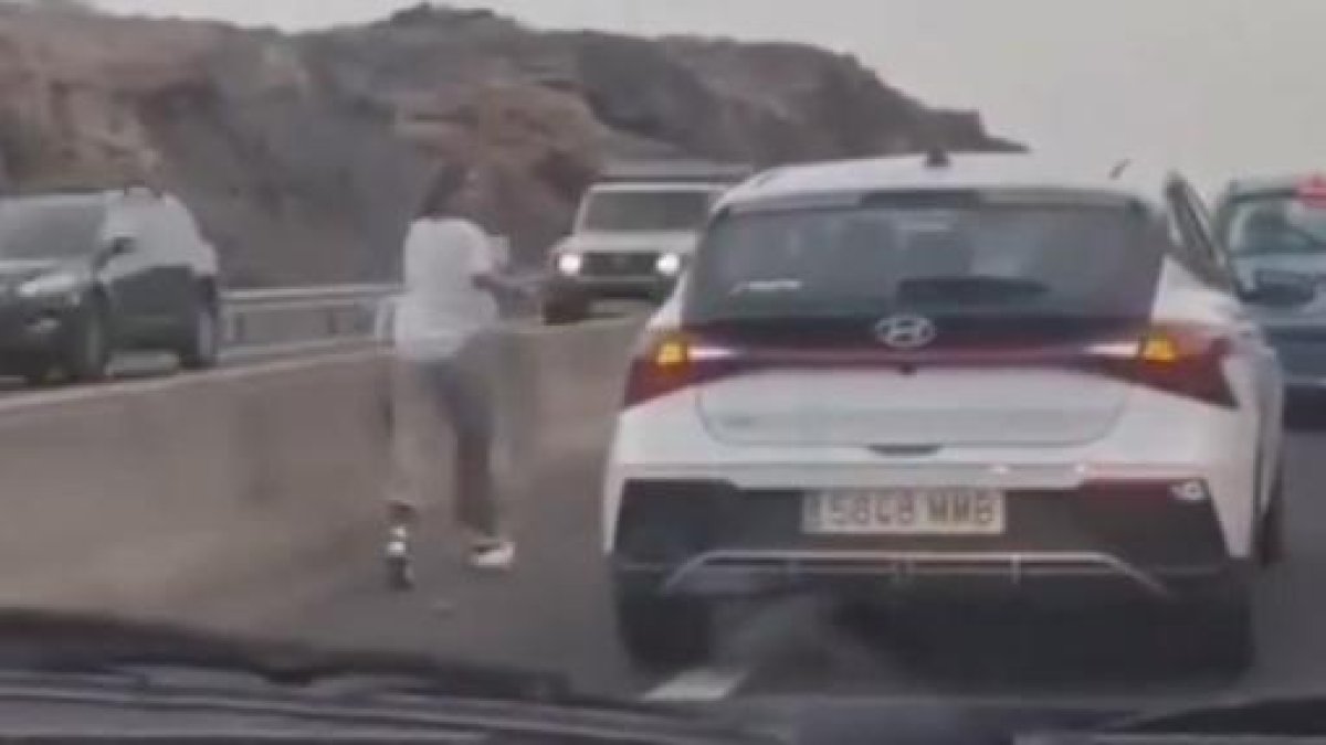 Es baixa del cotxe enmig de la carretera