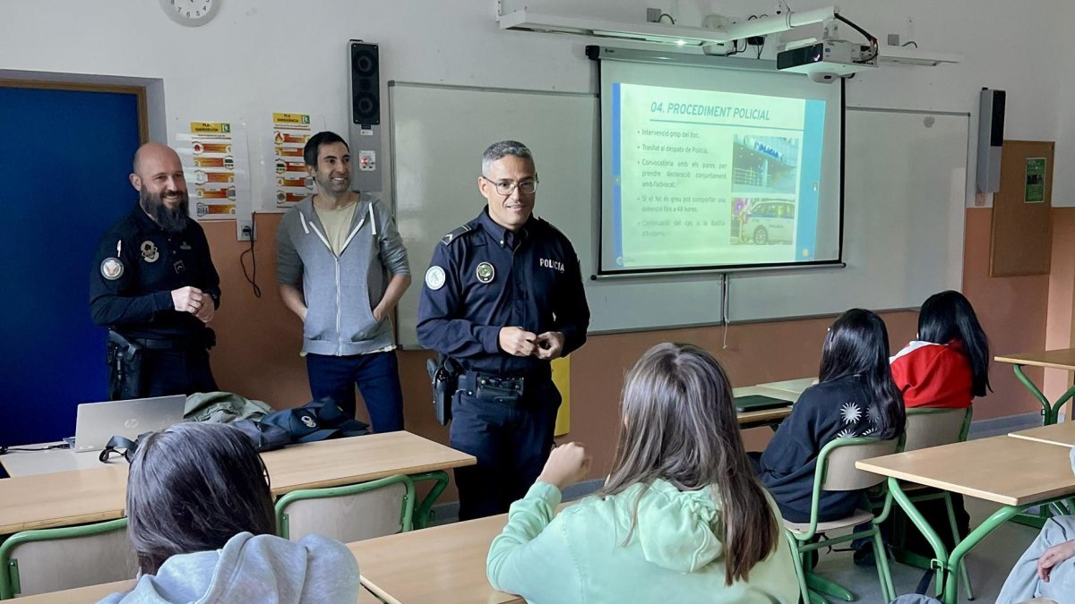 Una parella de policies en una aula durant una xerrada.