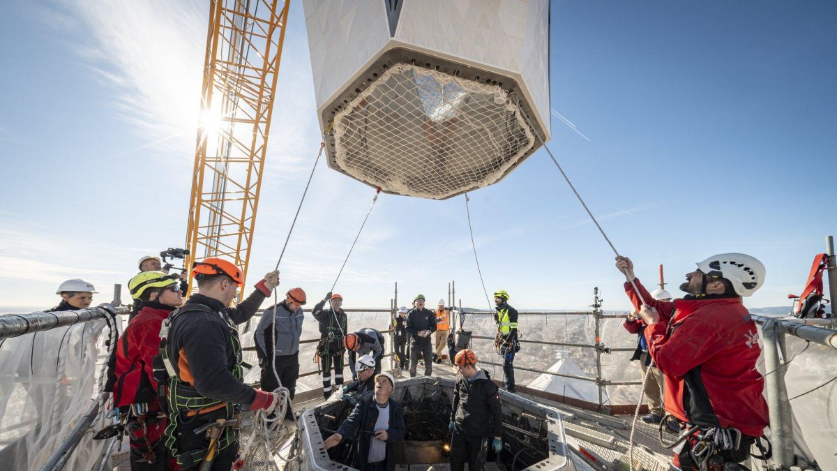 Operaris de la Sagrada Família posant l'últim bloc de la torre de Jesús.