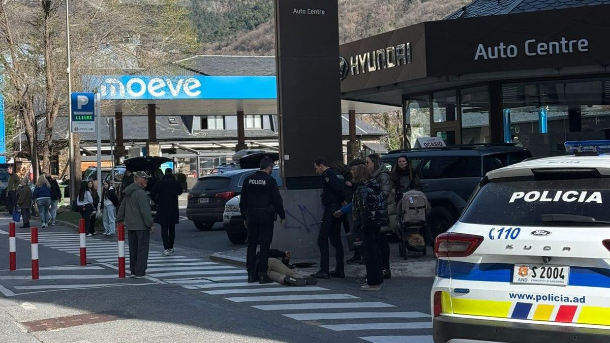 Dos agents de la policia amb una persona al terra per l'accident.
