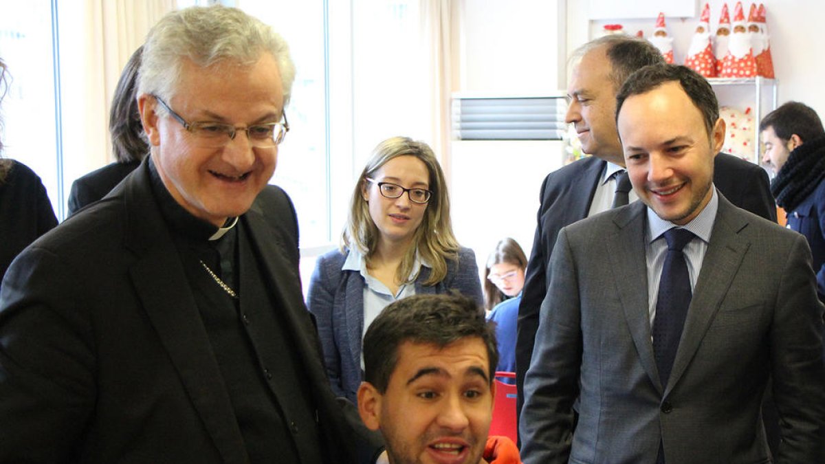 El copríncep episcopal, Joan-Enric Vives, el ministre d'Afers Socials, Justícia i Interior, Xavier Espot, amb un dels usuaris de l'Escola