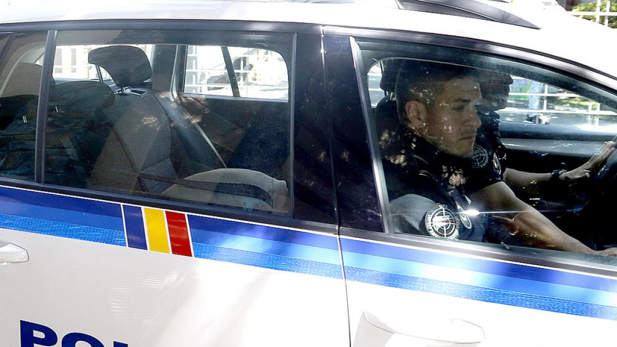Joan Pau Miquel, en el vehicle de la policia a l'entrada dels tribunals.
