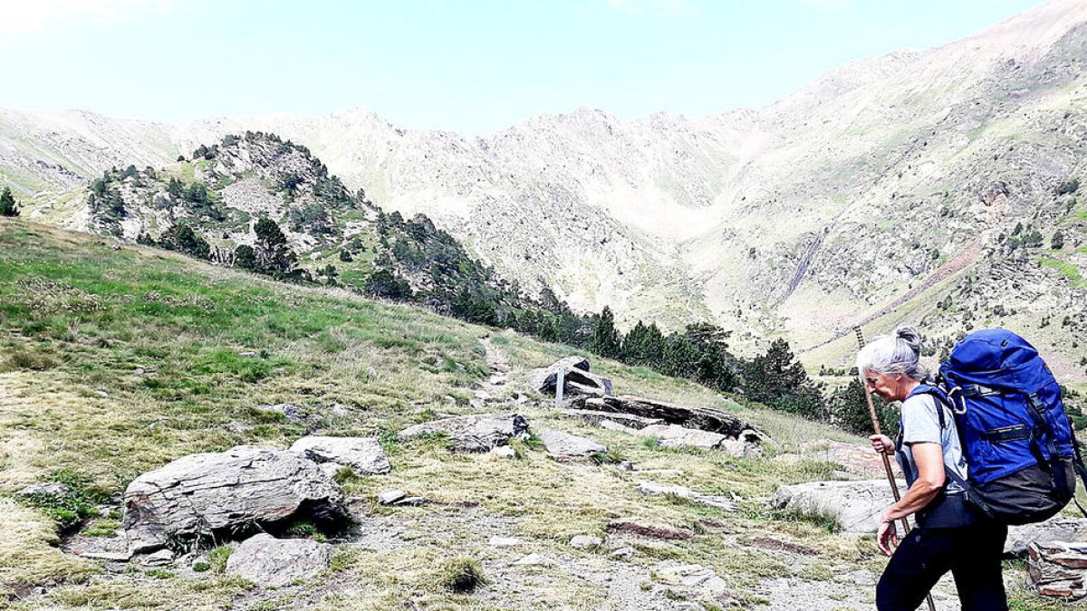 La guarda del refugi de Comapedrosa, Margaret Baró, caminant carregada per un dels camins propers al refugi.