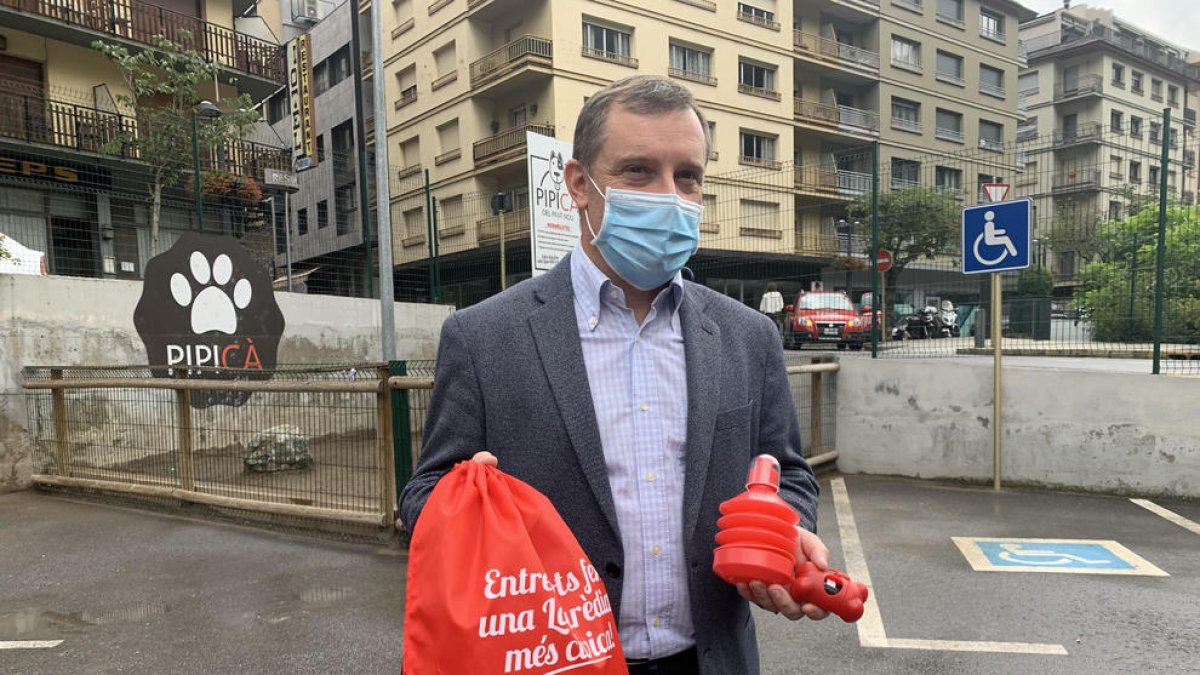 Josep Majoral mostra la bossa, l'ampolla d'aigua i l'estoig de bosses que regala el comú