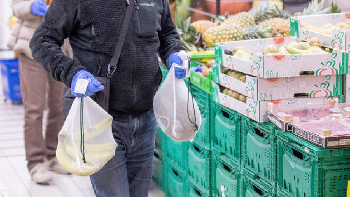 Un consumidor amb dos cistells de fruita.