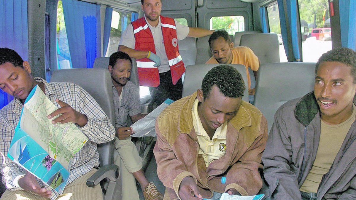 els cinc eritreus examinant un mapa d'Andorra al microbús que els porta al país.