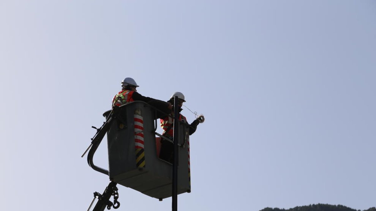 Operaris canviant l'enllumenat en un punt de la parròquia
