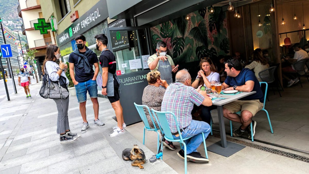 Un cambrer atenent un grup de clients en un restaurant del centre d'Andorra la Vella.