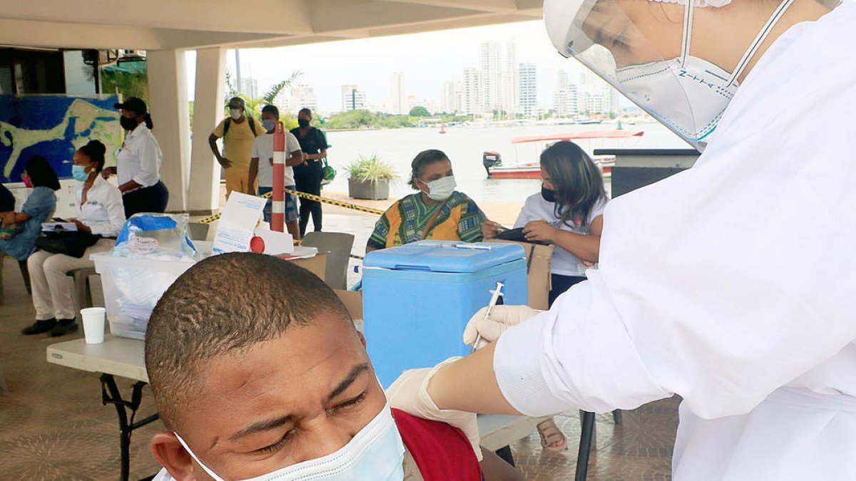 Un home rebent una dosi de la vacuna a Colòmbia.