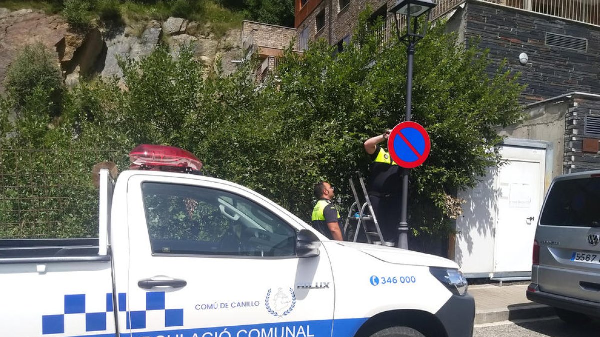 Els agents de circulació instal·lant els senyals de prohibició.