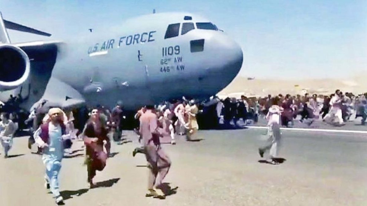 Civils afgans s'aglomeren a la pista d'enlairament de l'aeroport de Kabul.