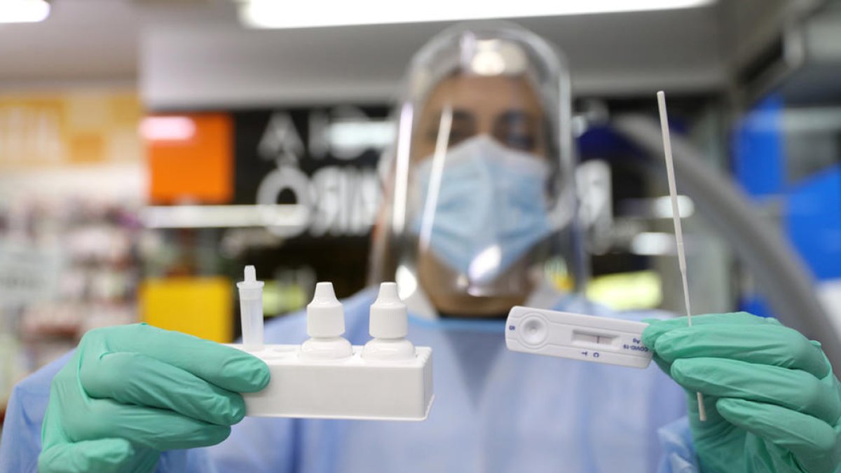 Un sanitari mostrant un test ràpid d'antígens.