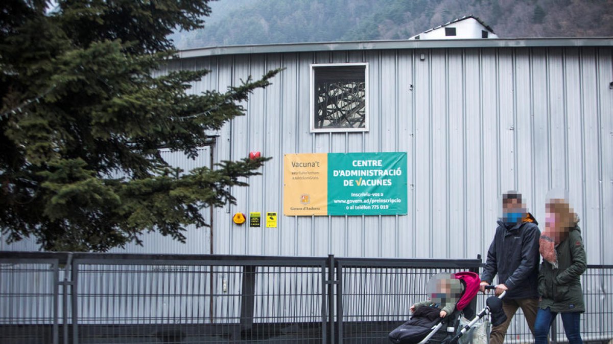 Una família amb un nen petit passa per davant del centre de vacunació.