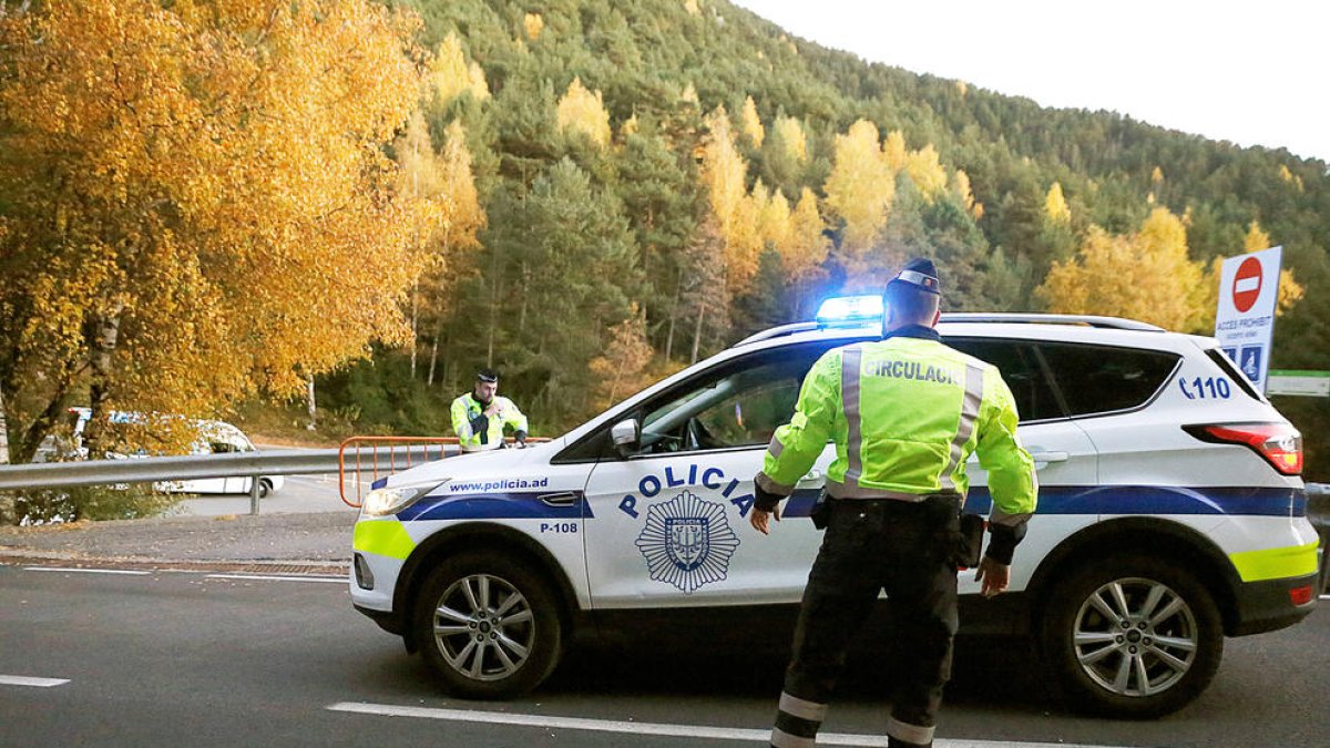 Dos agents de circulació i un vehicle de la policia.