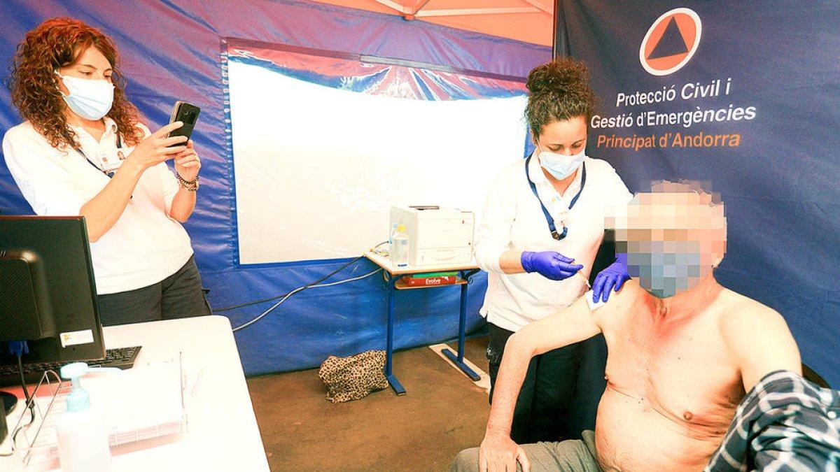 Una sanitària administrant la vacuna a una persona gran.