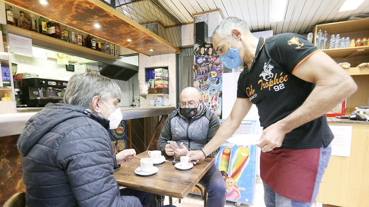 Dos usuaris prenent un cafè en un local de restauració.
