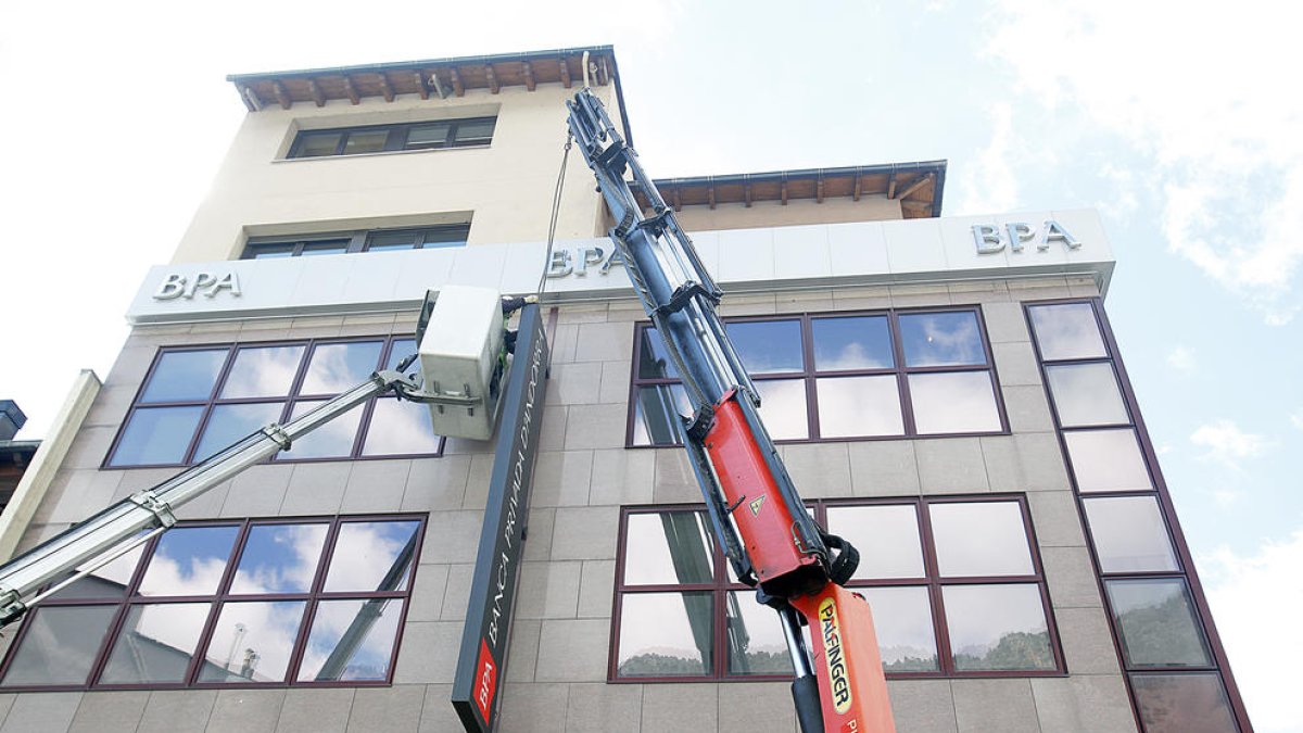 Les grues despenjant els cartells de les antigues oficines de BPA.