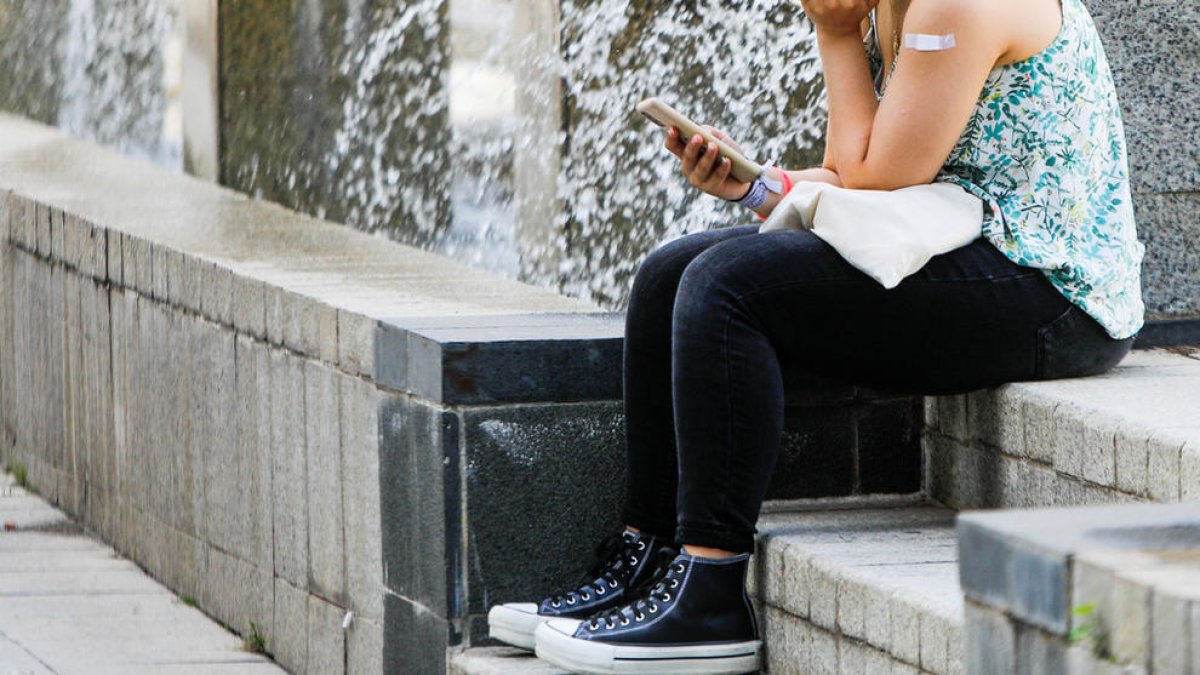 Una dona consulta el seu telèfon mòbil.