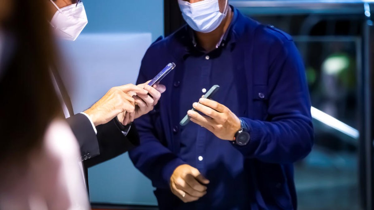 Un home ensenyant el certificat Covid perquè sigui validat.