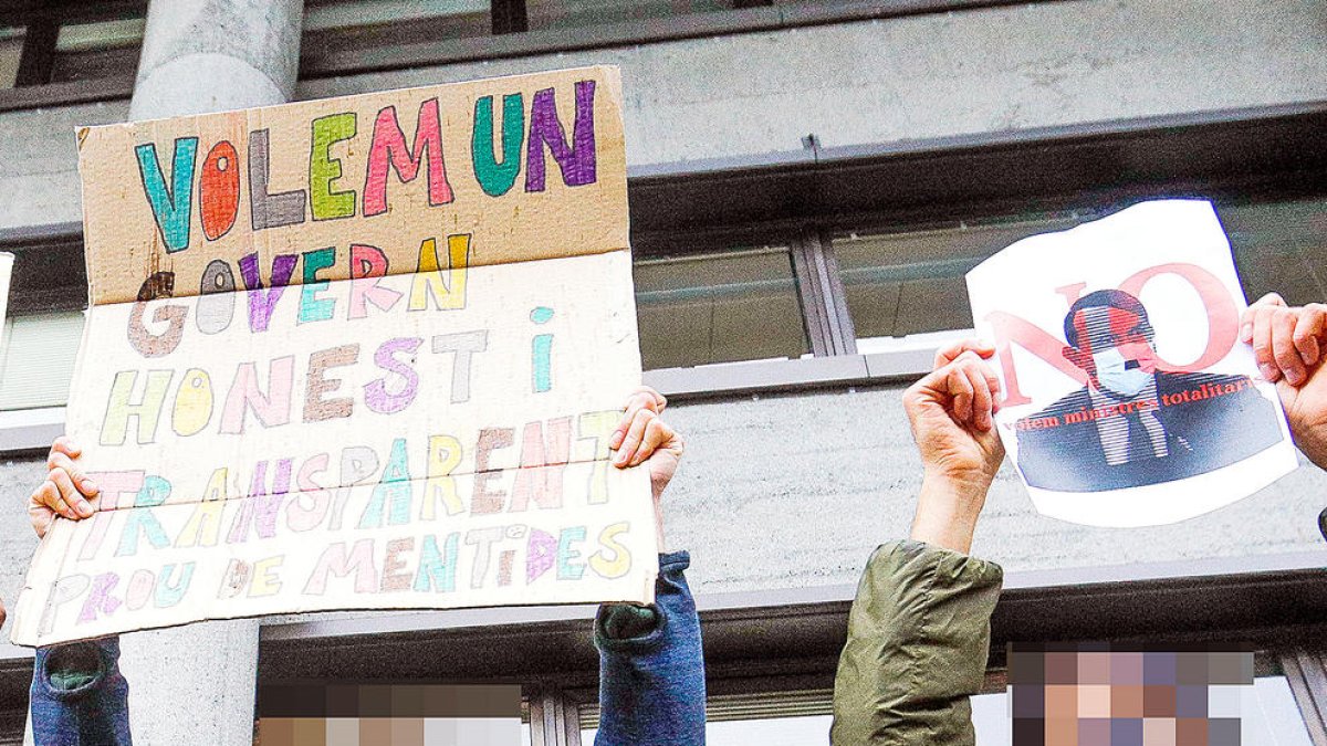 Pancartes de protesta, una de les quals assimilant el ministre Benazet amb Hitler.