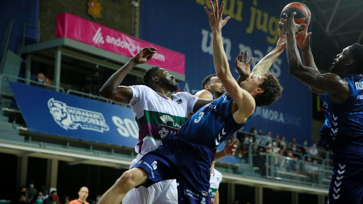 Oriol Paulí i Tunde Olumuyiwa lluiten per un rebot amb un jugador de l'Unicaja.
