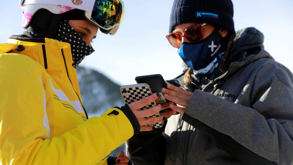 Una treballadora de Grandvalira verifica el codi QR d'una esquiadora.