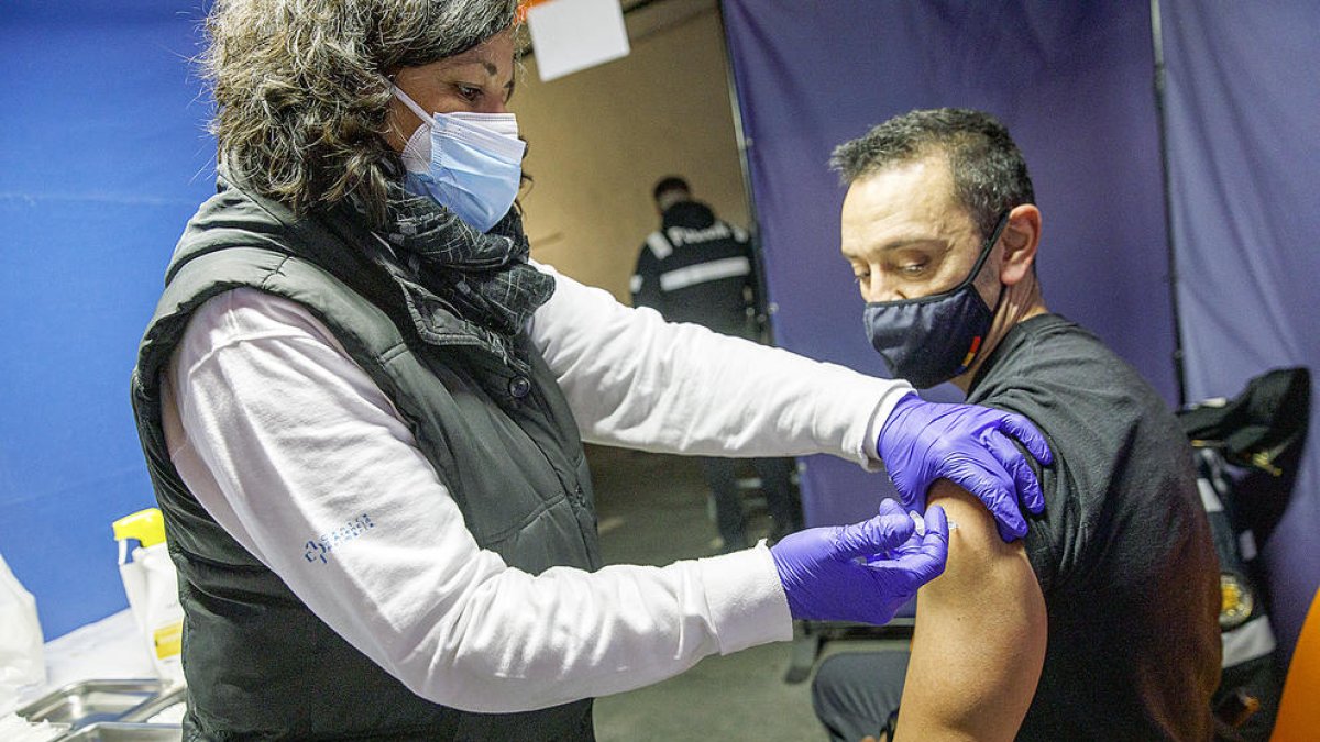 Una sanitària administrant una tercera dosi.
