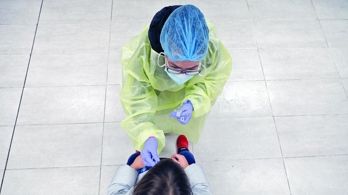 Una sanitària fent un test ràpid a una nena.