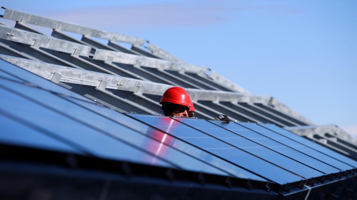 Operaris durant la instal·lació de les plaques.