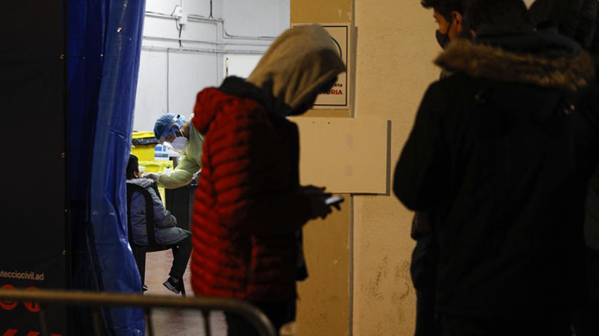 Un usuari fent cua al recinte de vacunació. Al fons, un nen practicant-se ahir una TMA.