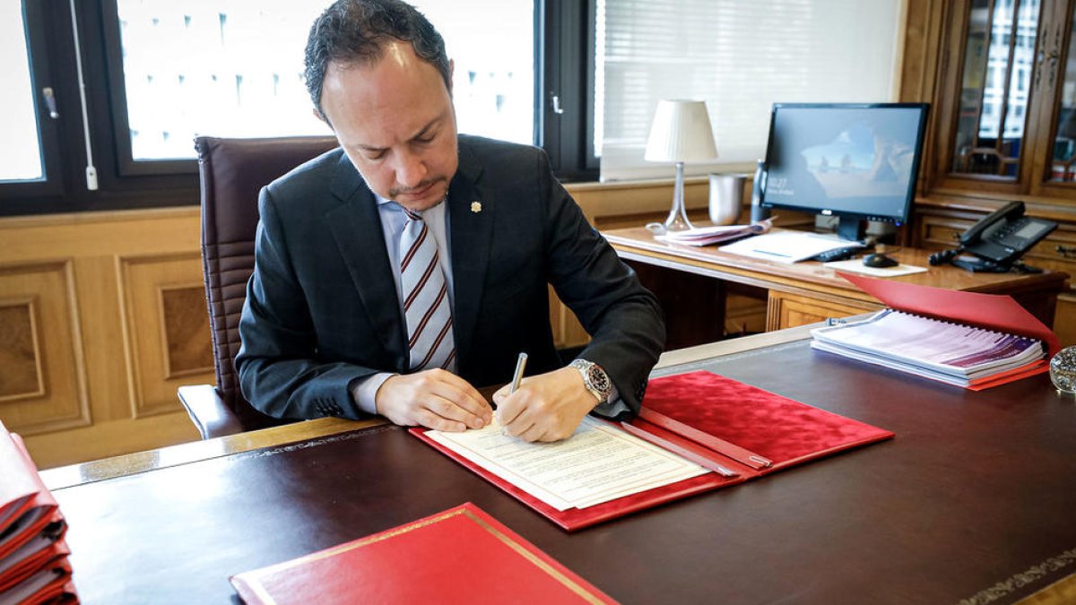 El cap de Govern signant el conveni.