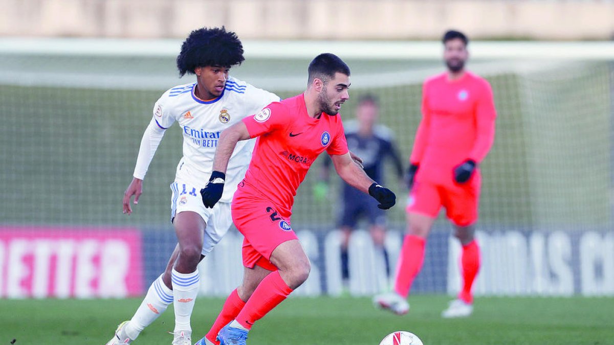 Martí Vilà mou la pilota sota la mirada de Peter González.