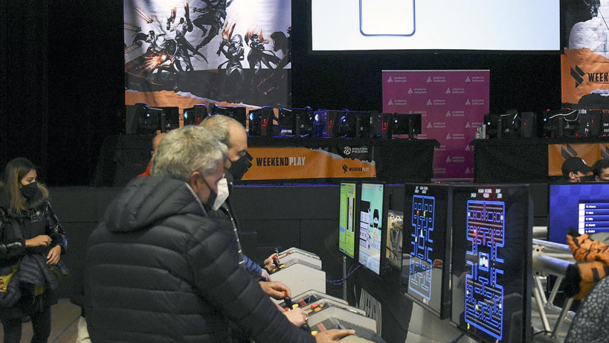 Pares i fills juguen a màquines d'arcade