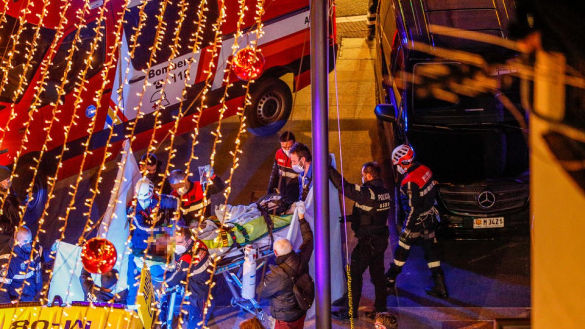 Els bombers enduent-se l'home ferit en l'ambulància.