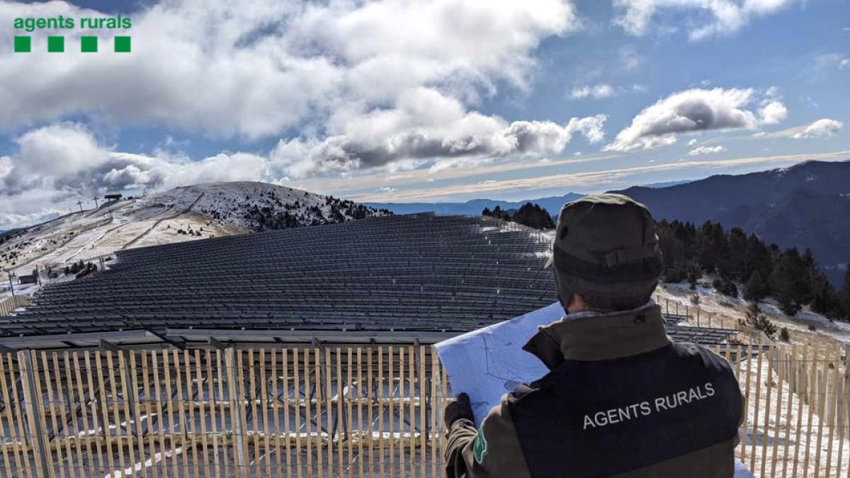 Un efectiu dels agents rurals inspeccionant amb el mapa cartogràfic la ubicació del parc solar.