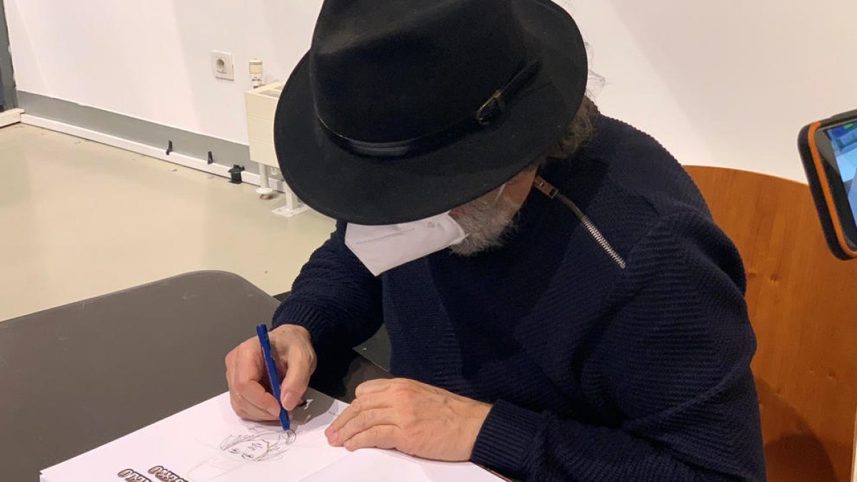 Mundet signant un exemplar de la seva obra