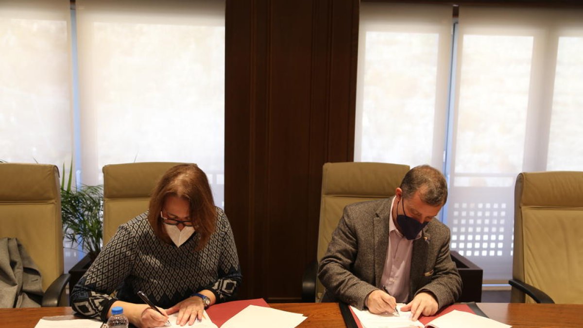 La presidenta i el cònsol major signant l'acord
