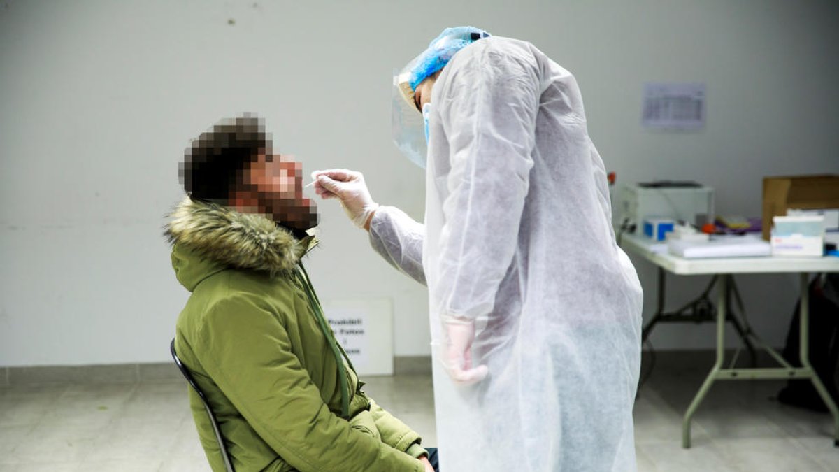 Una sanitària fent un test per detectar el coronavirus a un ciutadà.