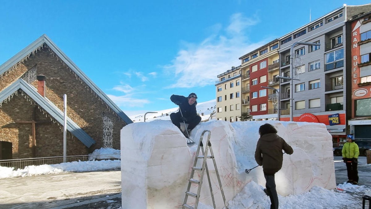 Els tres artistes treballant en l'escultura de neu al Pas