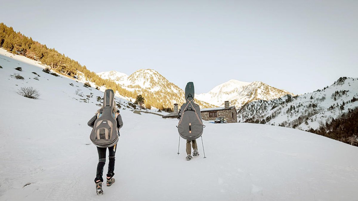Els dos músics arribant al refugi de Sorteny amb els instruments.