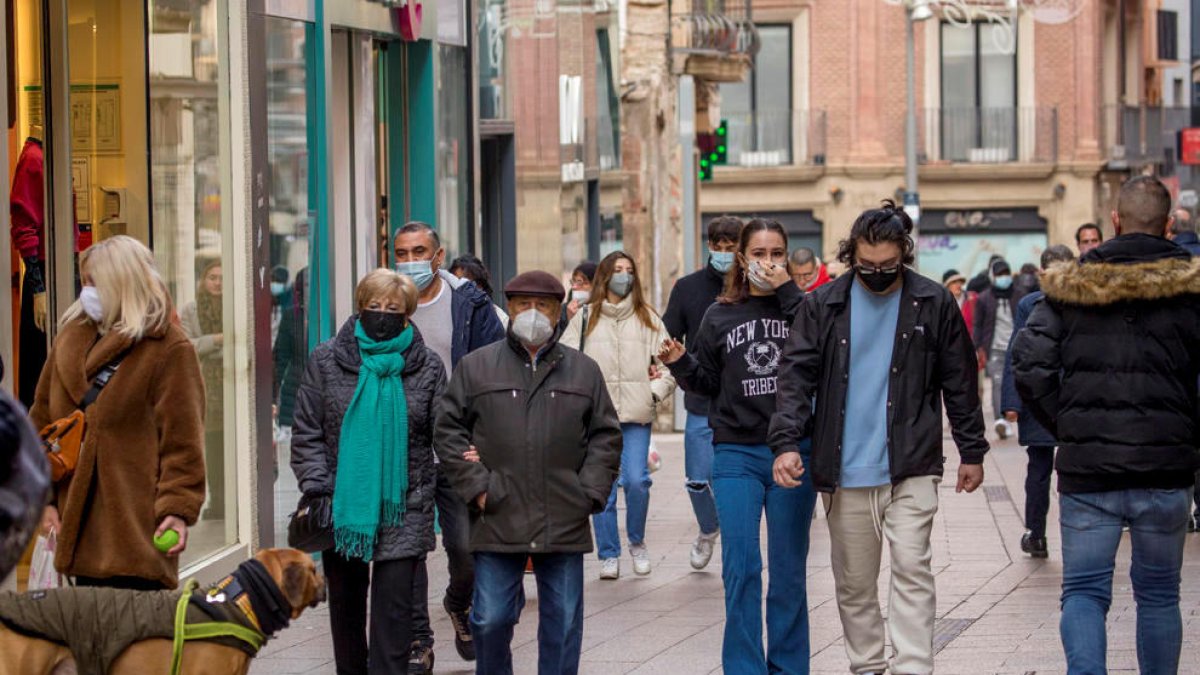 Persones caminant per Lleida amb la mascareta.