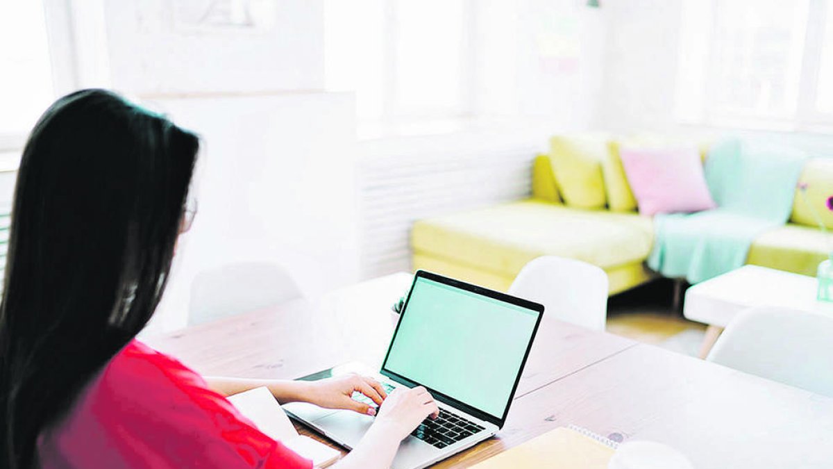 Una persona teletreballant al seu domicili.