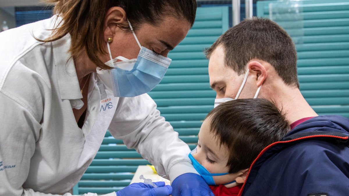 Un infant rebent el vaccí.