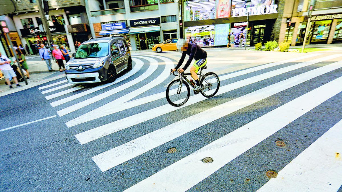 Un ciclista circulant per la cruïlla entre l'avinguda Meritxell i el carrer Prat de la Creu.