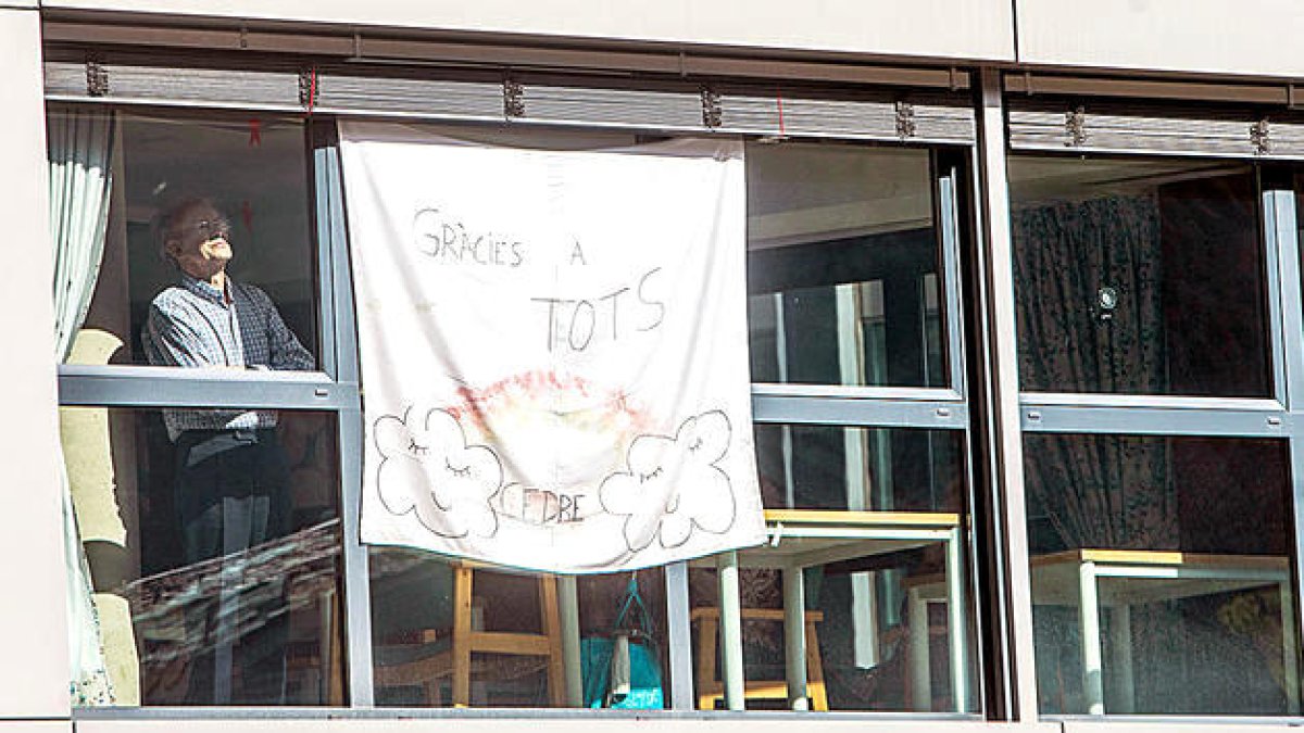 Un padrí mirant per la finestra al centre sociosanitari El Cedre.