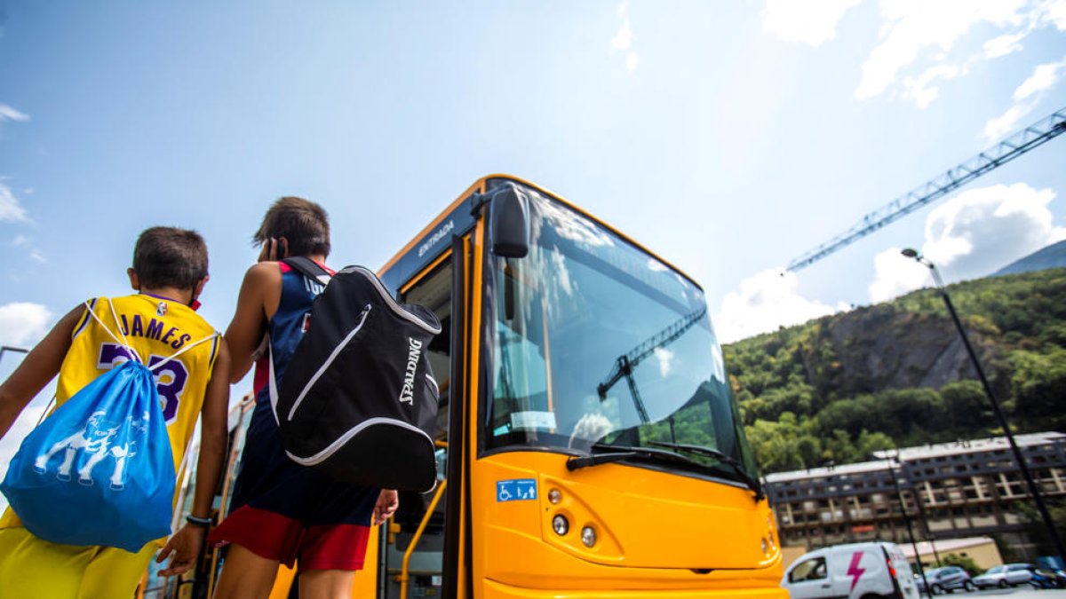 Dos nens pujant a un autobús.