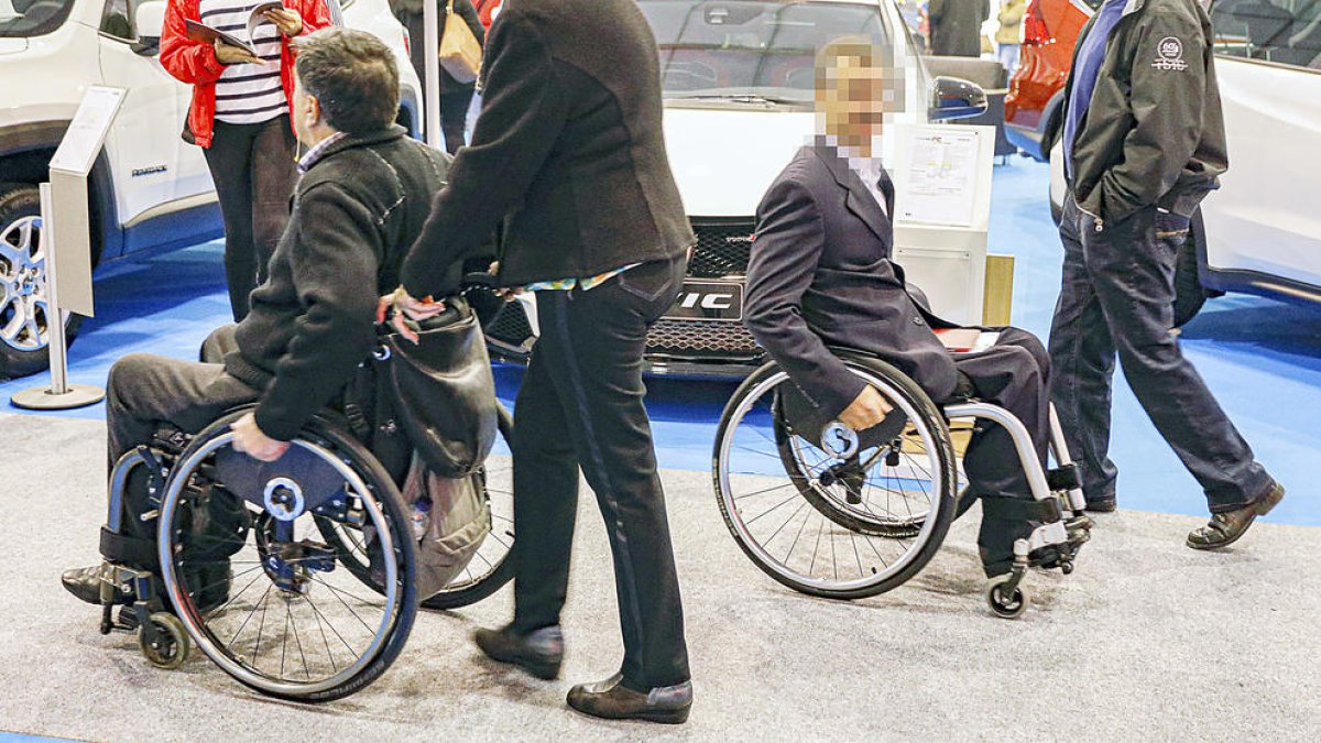 Dues persones amb cadires de rodes a la Fira d'Andorra la Vella.