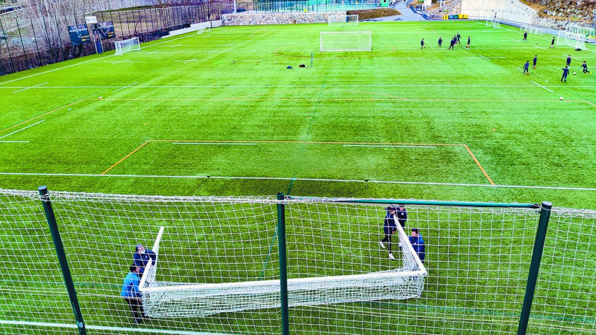 Operaris col·locant una porteria a l'estadi de Prada de Moles.