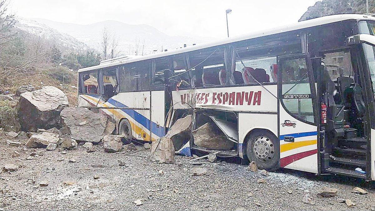 Un dels autobusos afectats per la caiguda del roc.